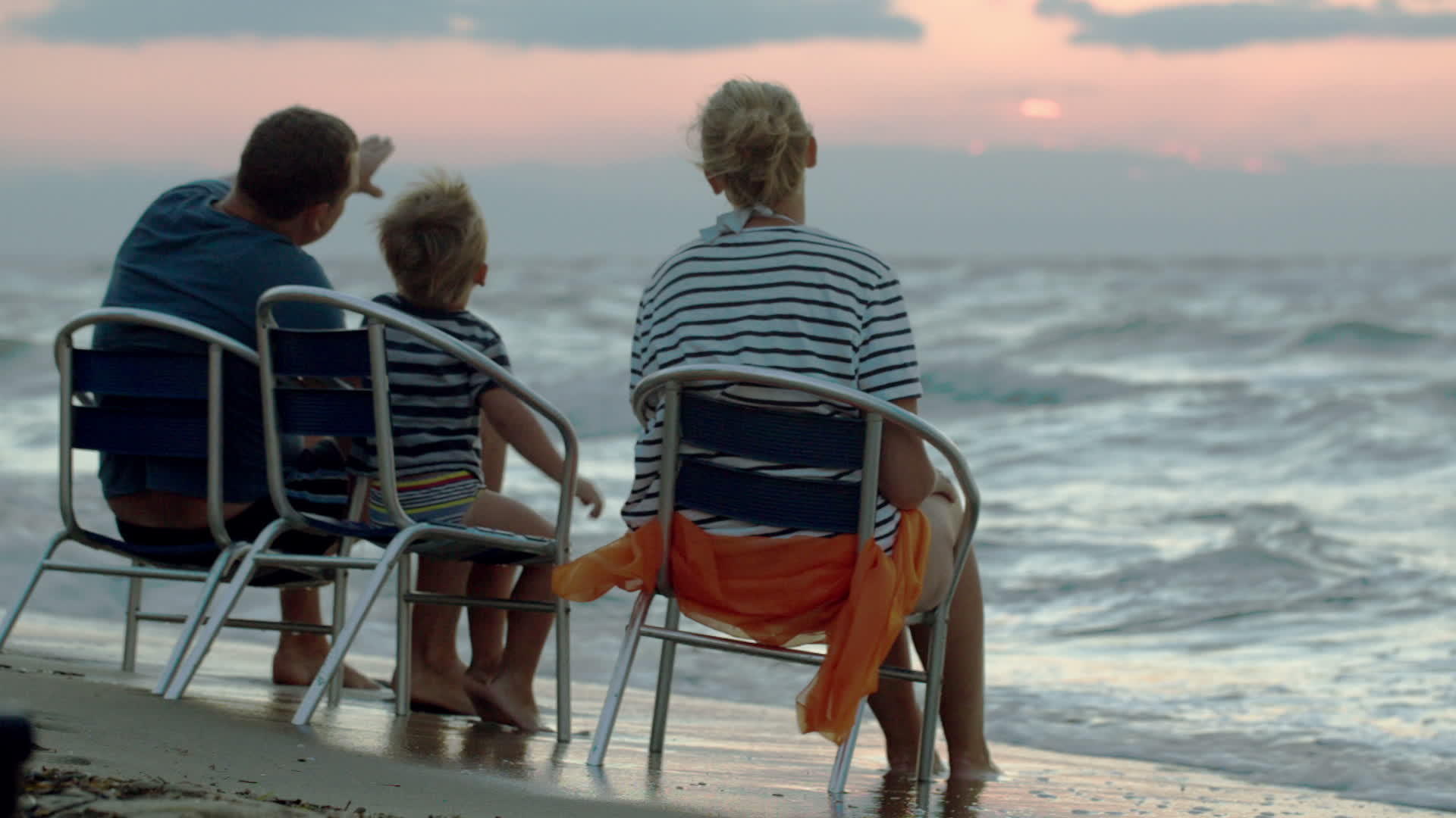 日落时分三个人坐在海边的椅子上视频的预览图