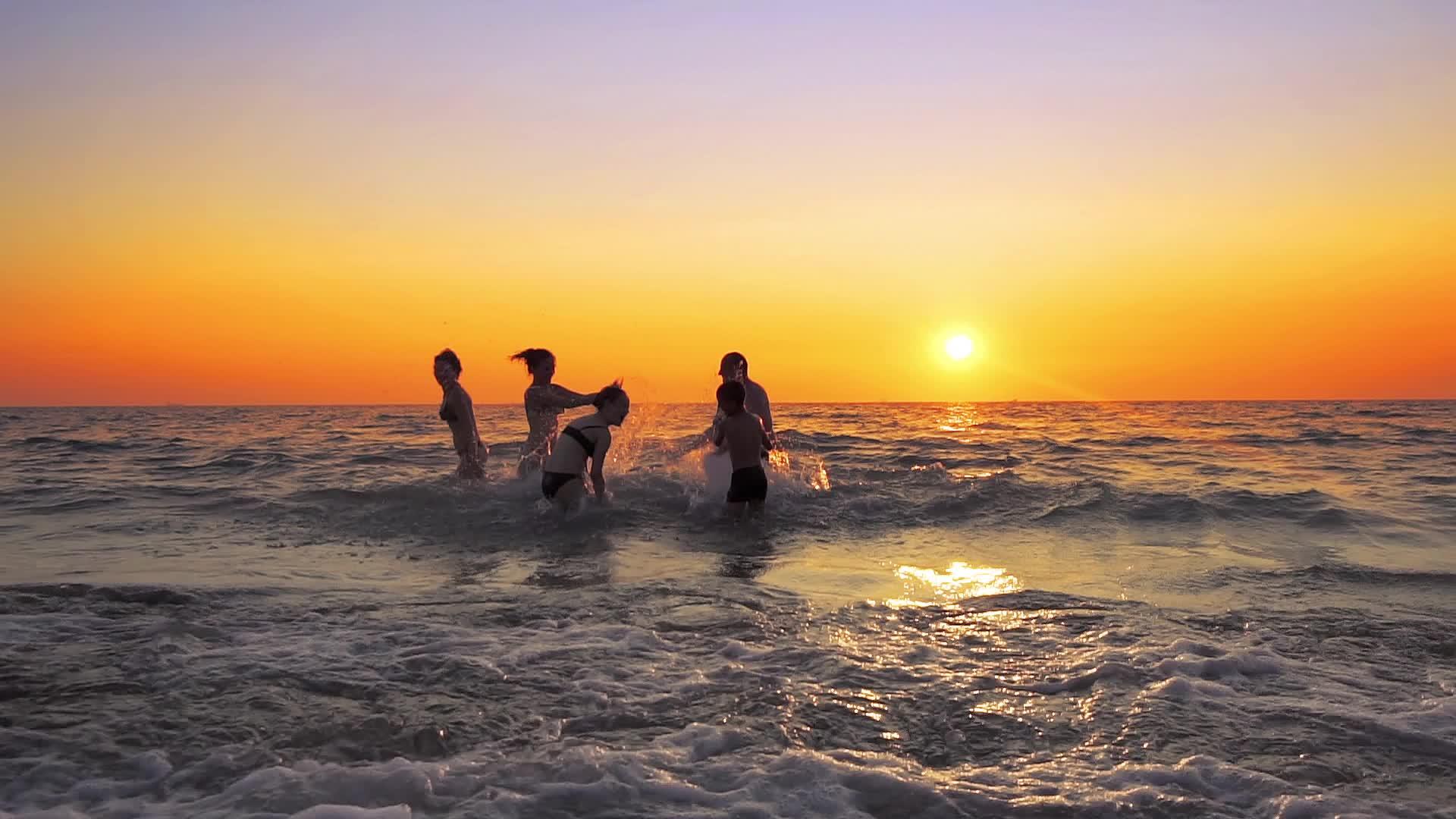 一群年轻的嬉皮士在日落时在海滩派对上玩耍视频的预览图