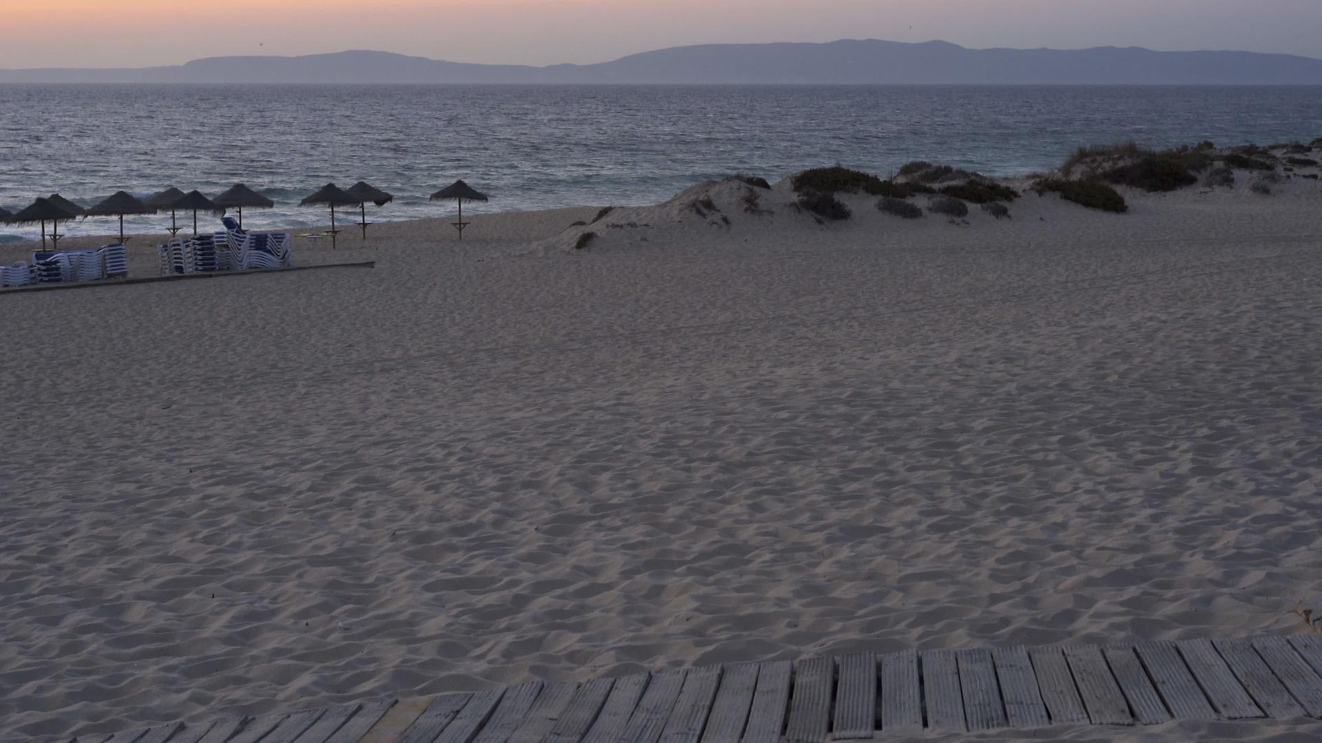 康波尔塔脚下的日落时空海滩和草伞视频的预览图