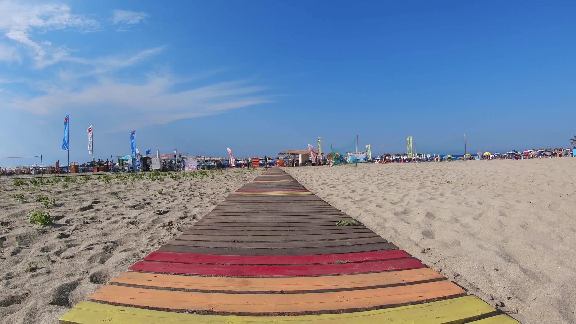 走在金色沙滩上的木地板上视频的预览图