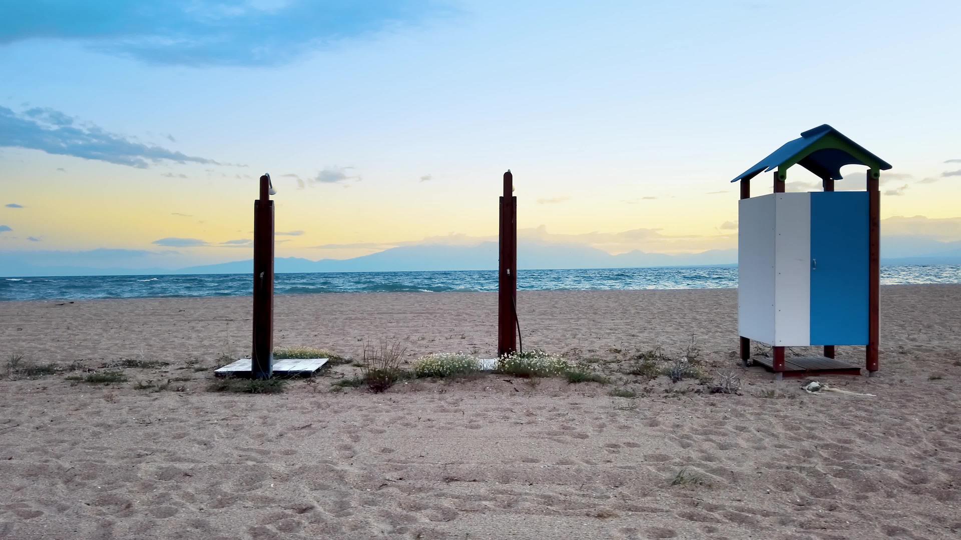 日落时海滩上的木制更衣室有着丰富多彩的更衣室假期概念视频的预览图
