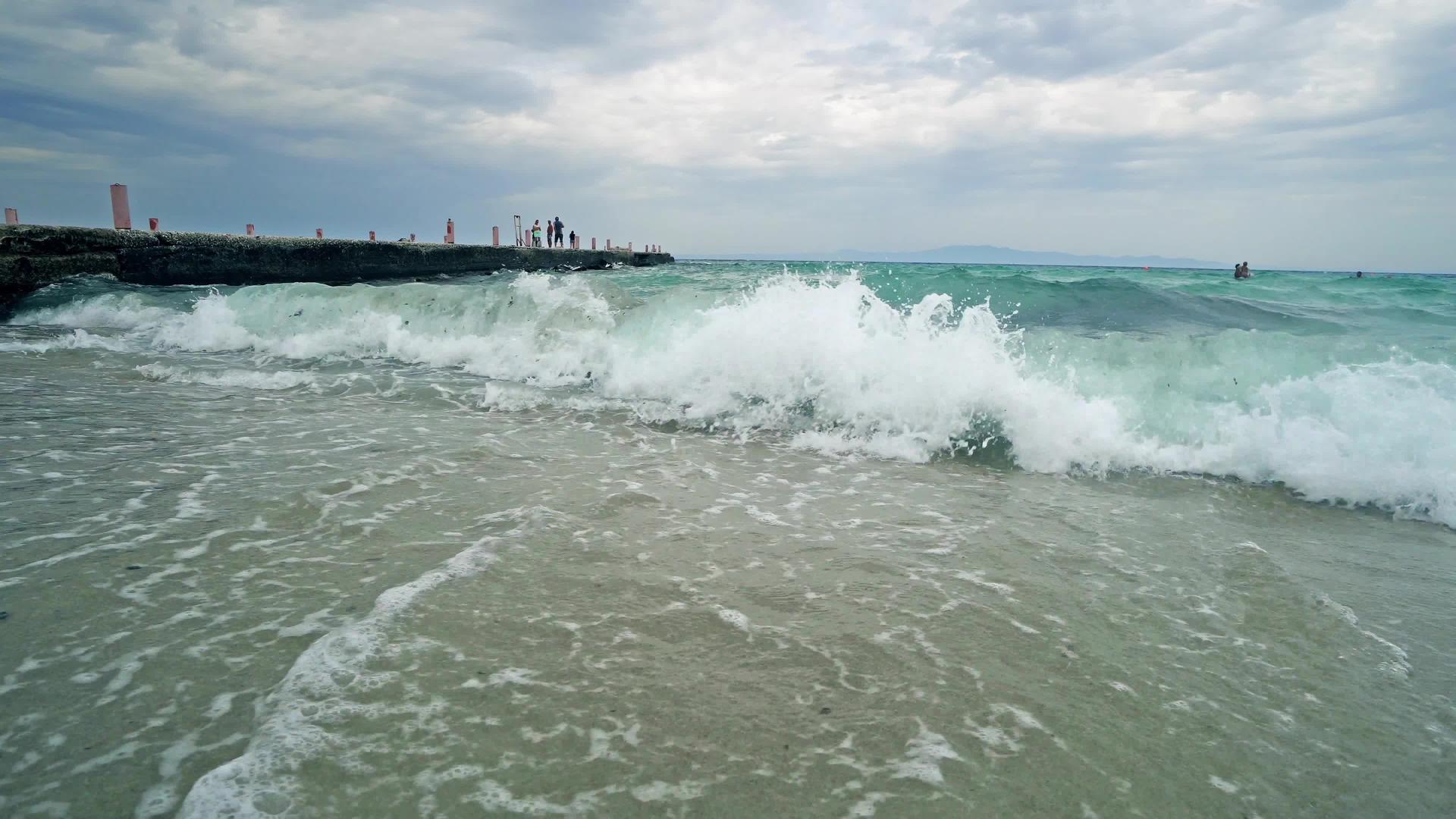 海滩上的海浪破碎背景有码头视频的预览图