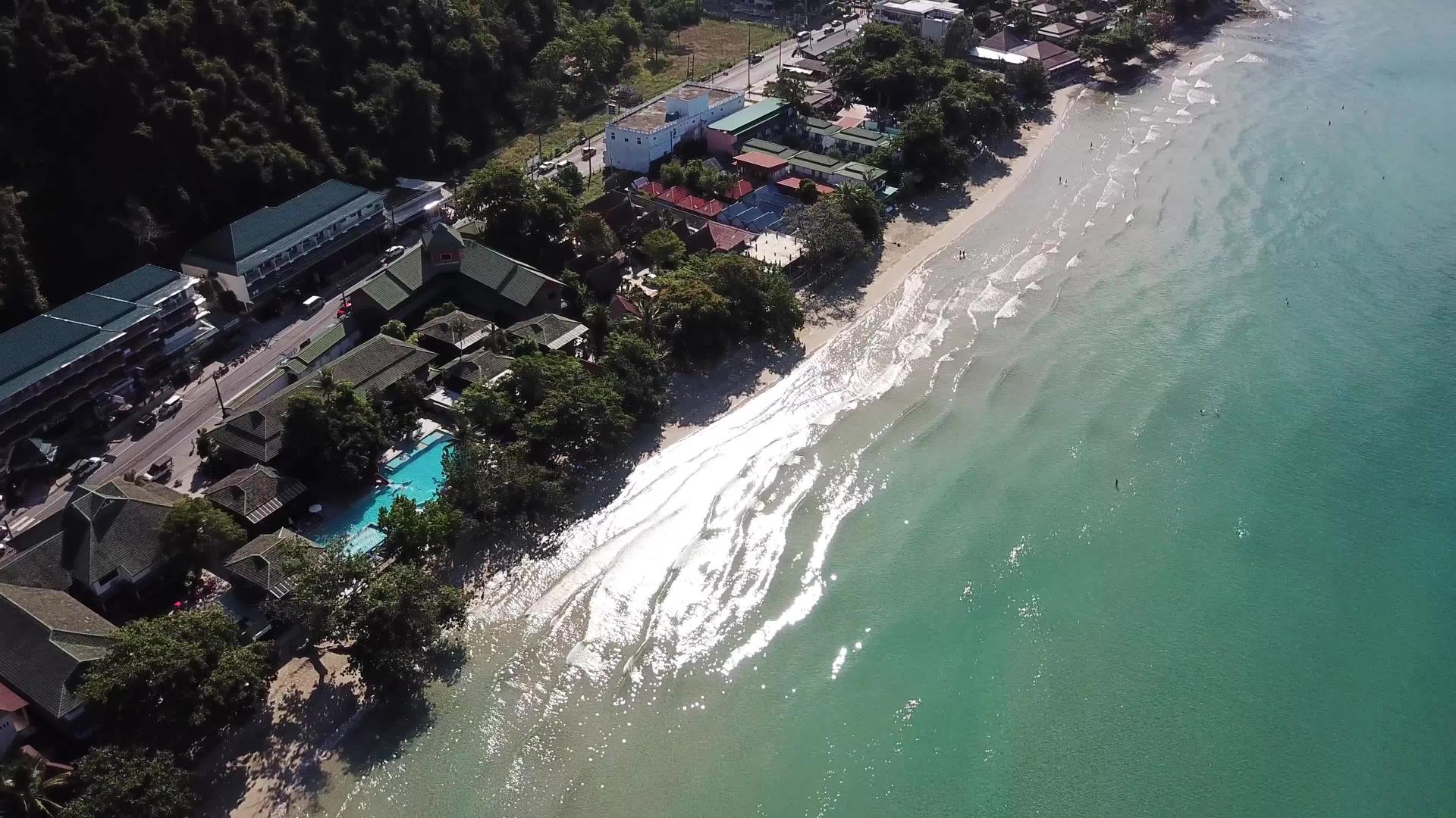 驾驶无人机酒店游泳池棕榈树在长岛海滩的第一条海岸线上视频的预览图