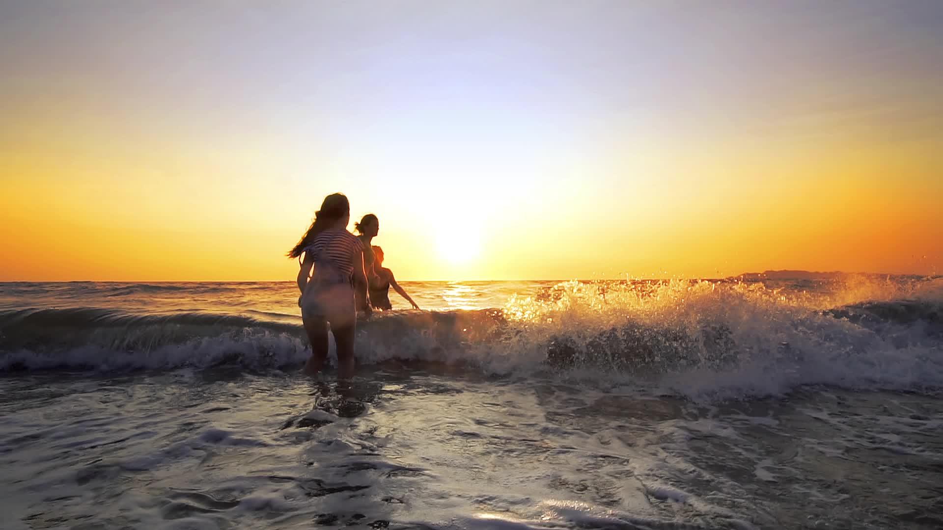 一群女朋友在日落时在海滩上玩耍和冲浪像电影一样慢慢摇摆视频的预览图