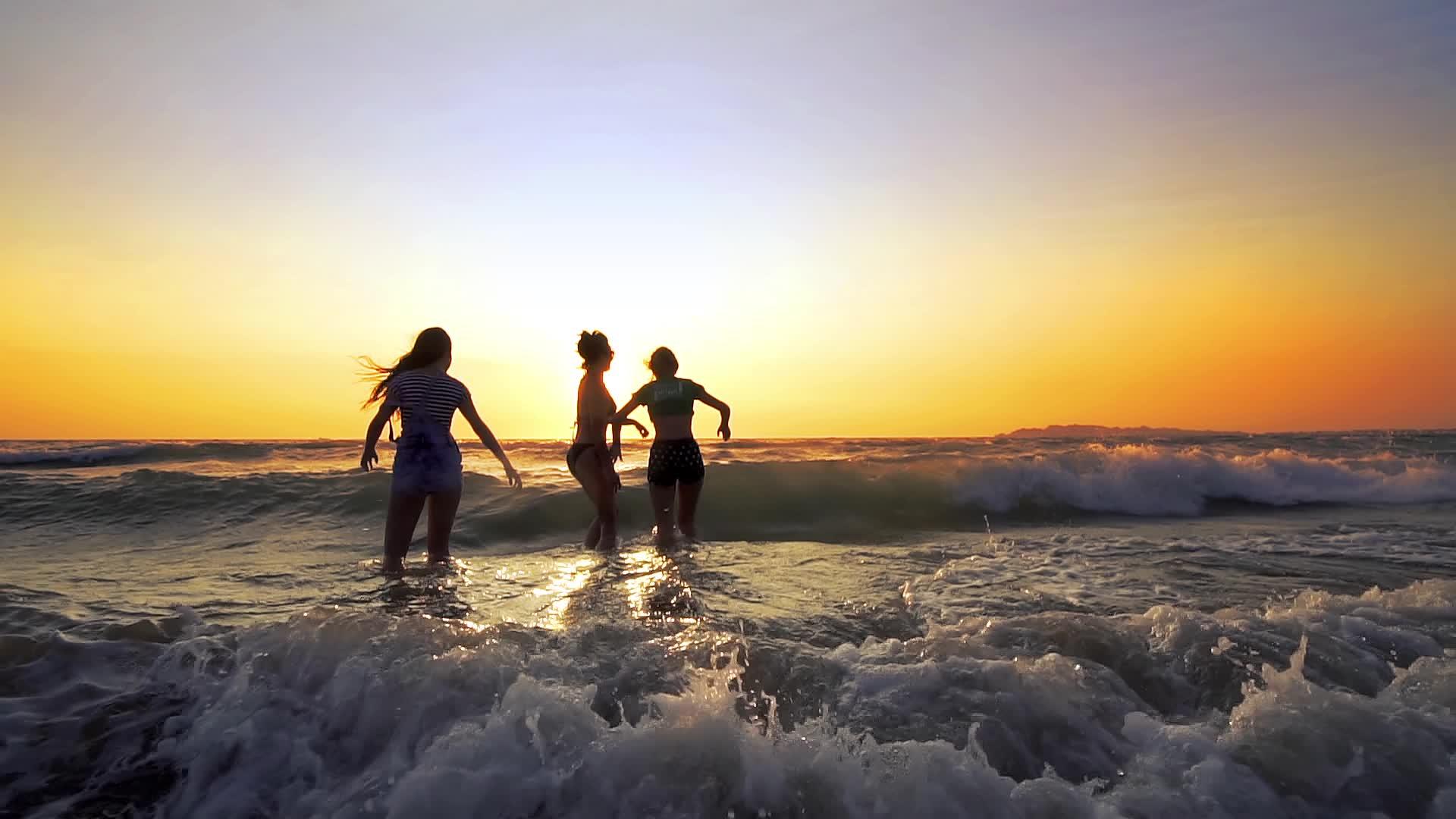 一群快乐的女孩在日落时在海滩上玩耍美丽快乐的年轻朋友视频的预览图