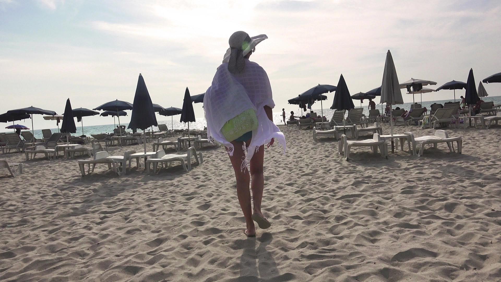 沙滩椅和太阳伞之间美丽无忧无虑的女孩视频的预览图