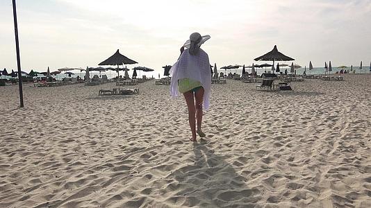 美丽的西班牙女孩沿着海滩漫步没有忧郁视频的预览图