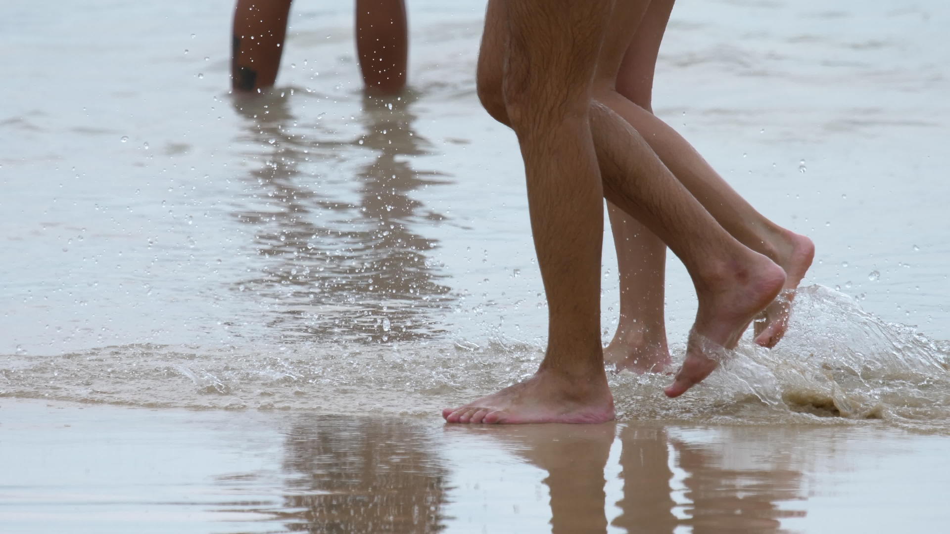 一对夫妇在海滩上散步双腿紧合在一起视频的预览图
