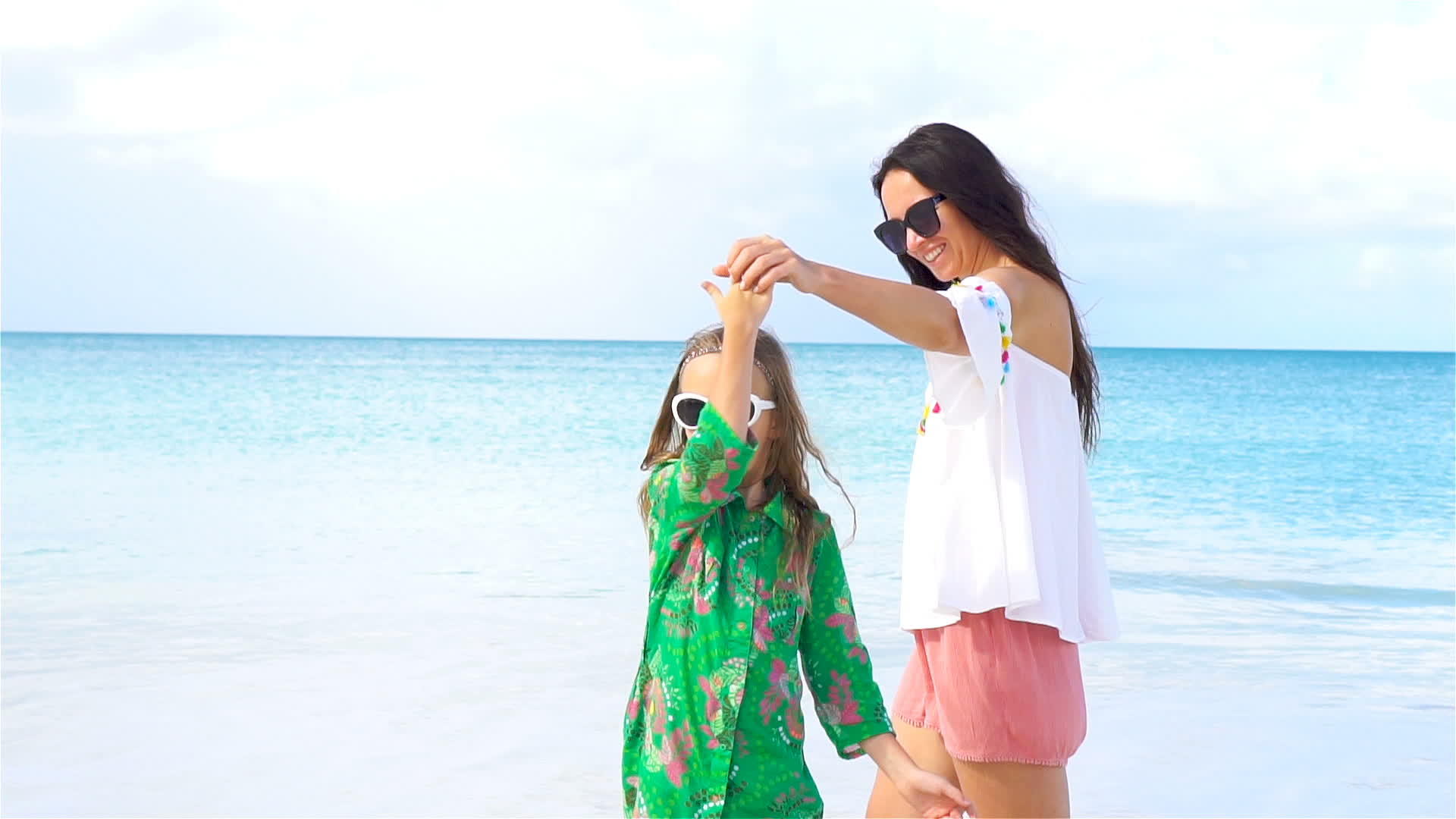 女孩和年轻的母亲在海滩上玩得很开心视频的预览图
