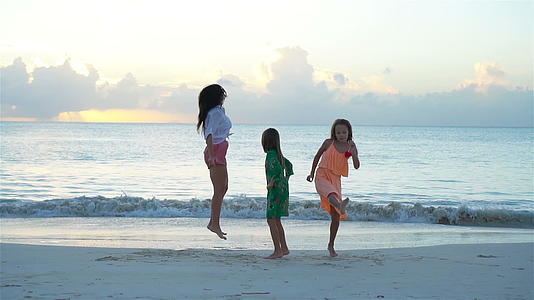 可爱的小女孩和年轻的母亲在白色的海滩上视频的预览图