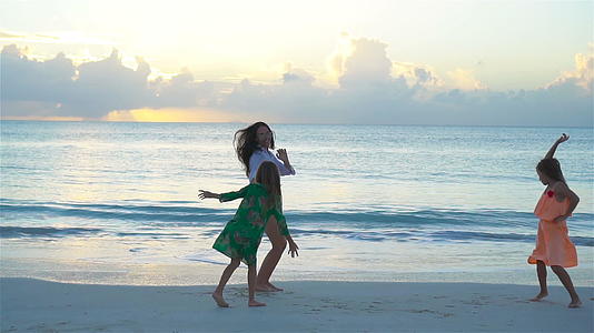 可爱的小女孩和年轻的母亲在白色沙滩上玩得开心又慢视频的预览图