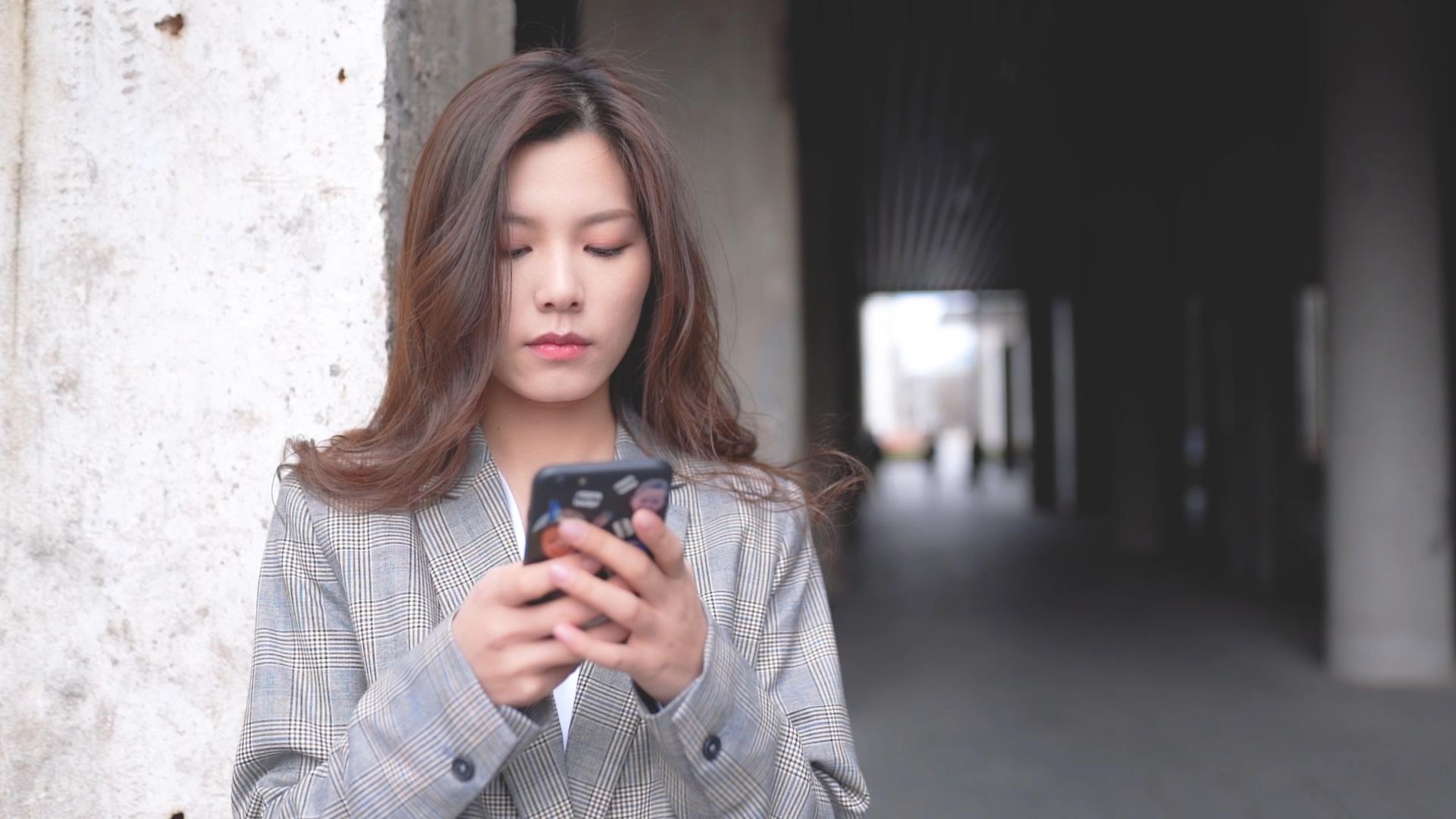 站在过道的职场女性使用手机视频的预览图