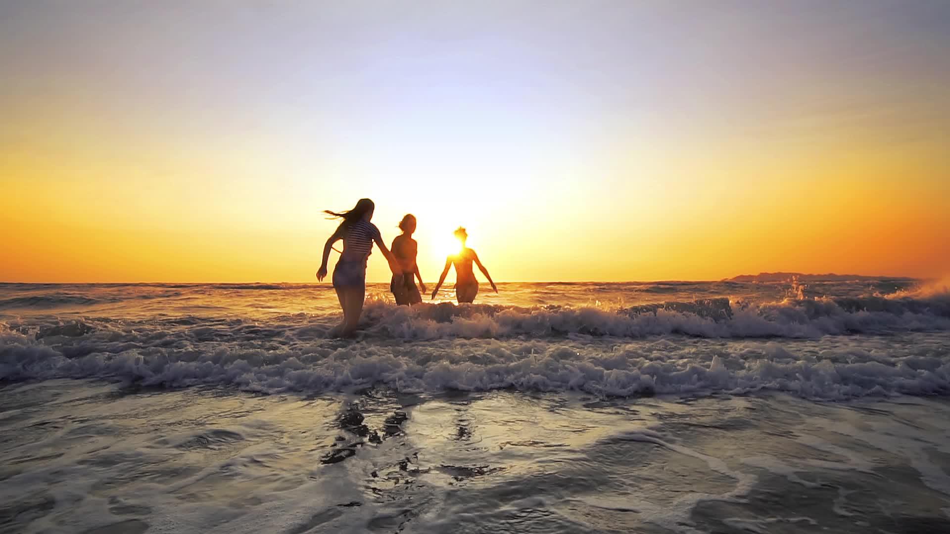 快乐的青年聚会人们在海滩日落时跳舞和喷洒喷雾视频的预览图