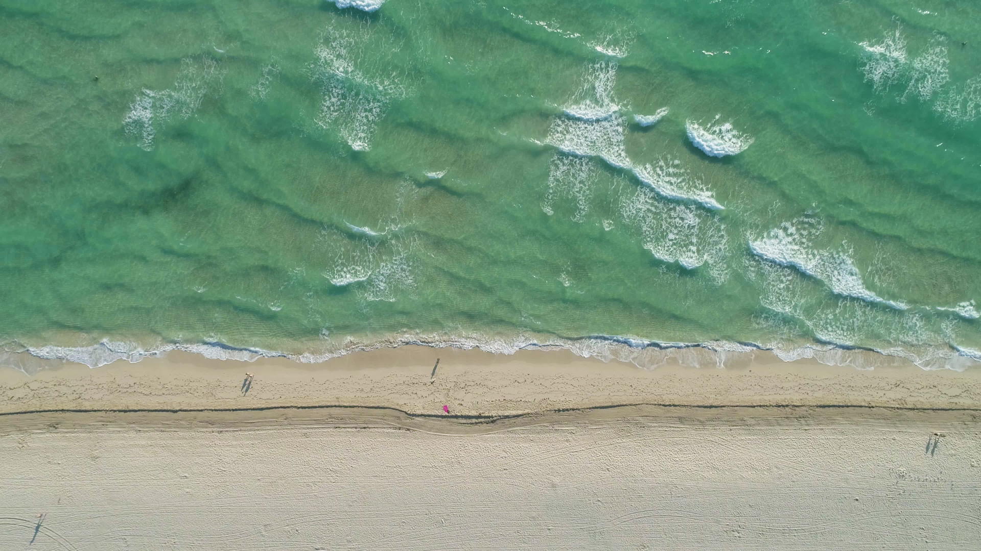 在阳光明媚的白天海浪和海滩从上到下垂直地从上到下视频的预览图