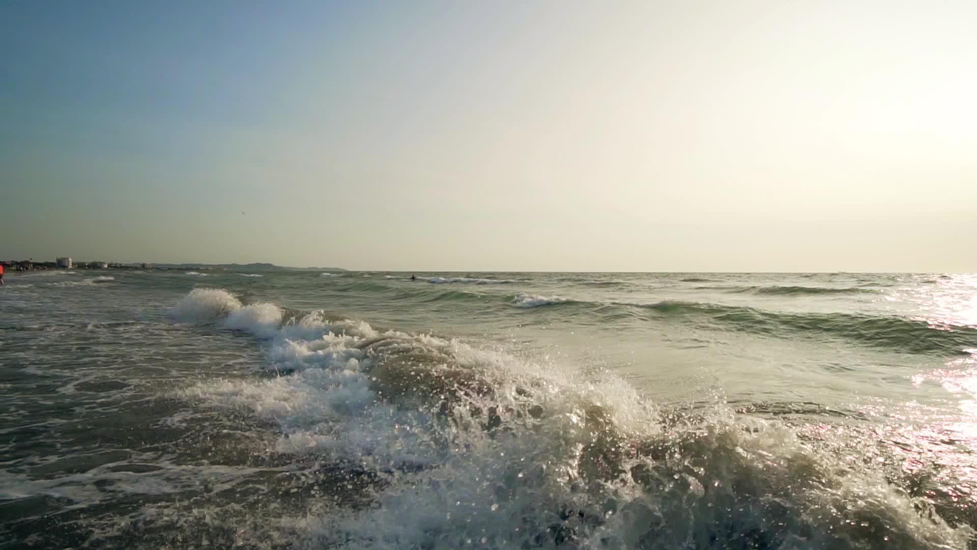 在阳光下喷洒异国海滩海浪的惊人背景视频的预览图
