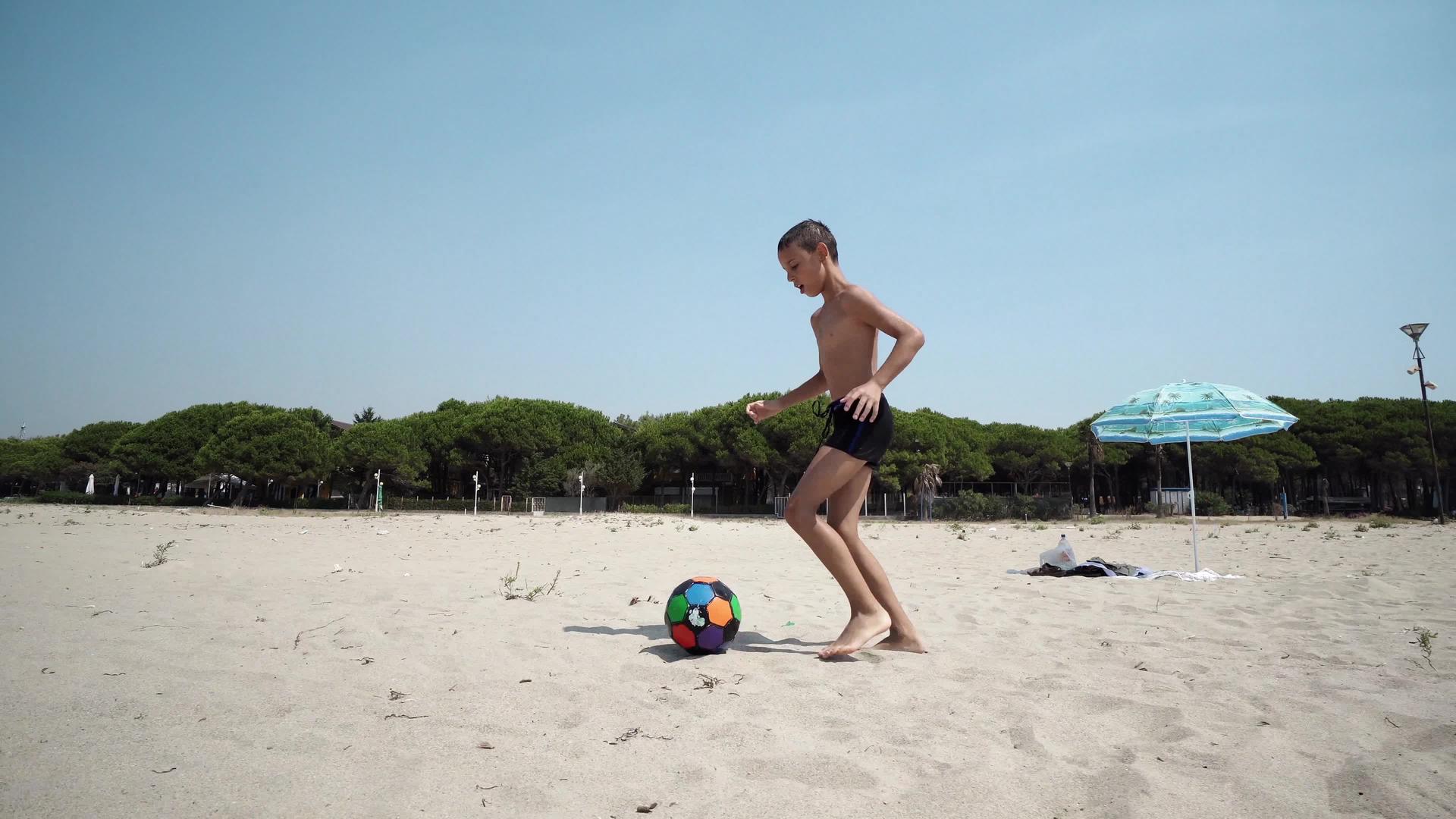 一个足球男孩在海滩上踢足球电影史坦肯拍了一个球视频的预览图