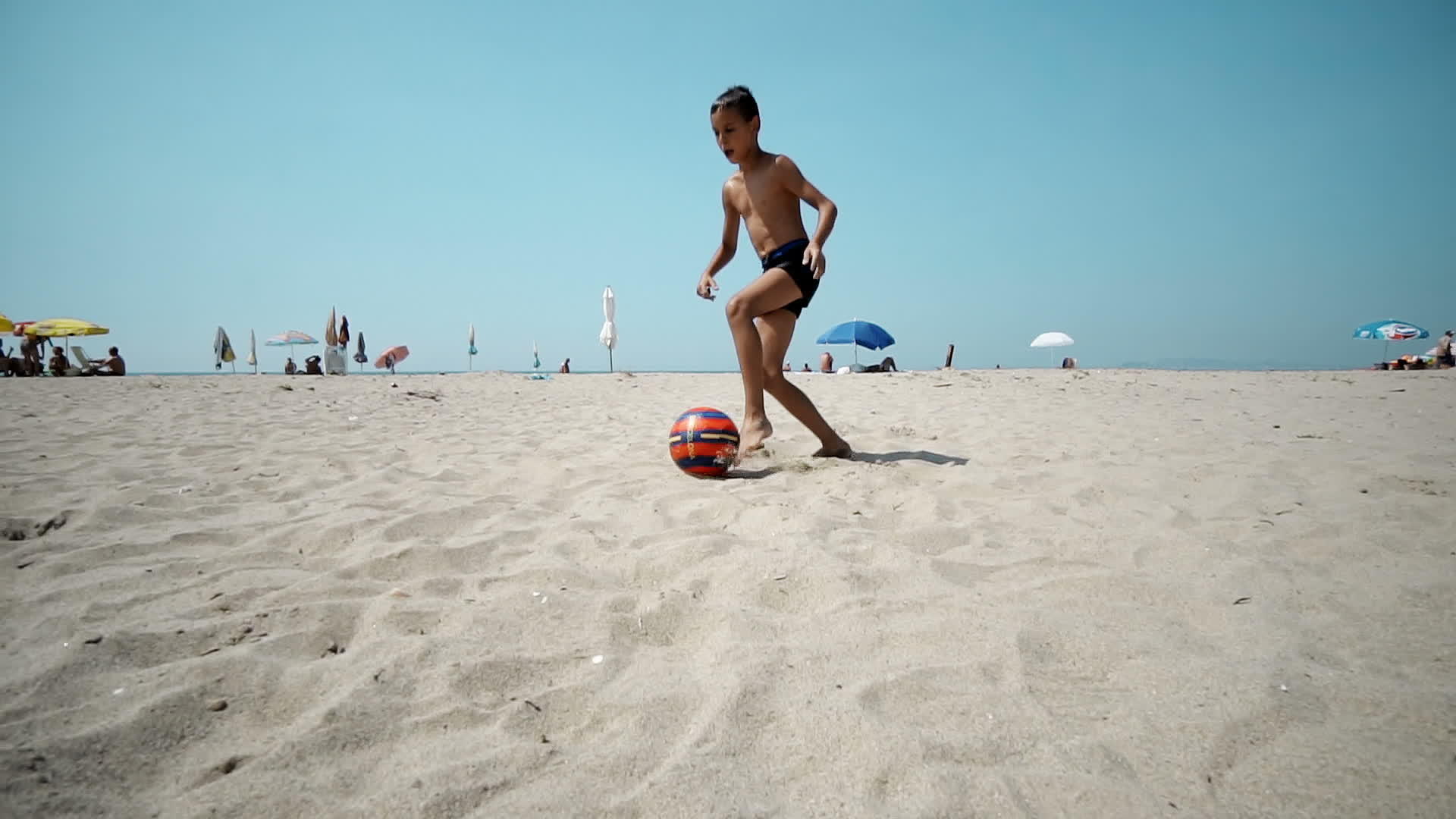 孩子们在沙滩上慢慢地踢足球视频的预览图