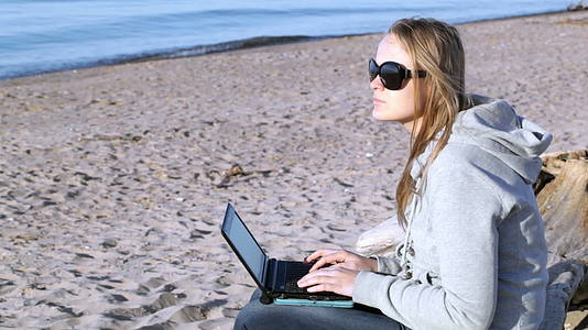 在海滩上使用笔记本电脑太阳镜视频的预览图