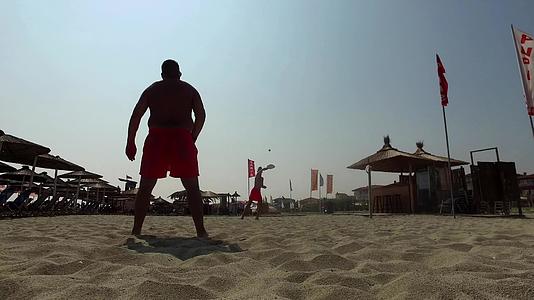 活跃在热带海滩玩网球的年轻年轻光影游客视频的预览图