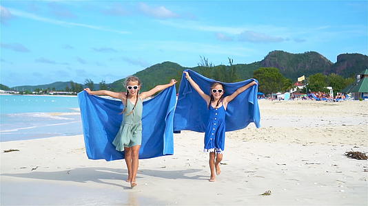 快乐的小女孩们在热带海滩上玩得很开心慢动作掌声视频的预览图