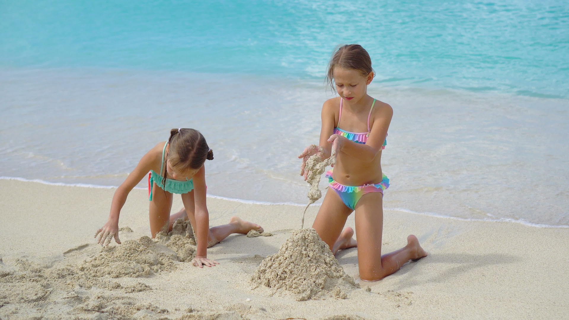 两个快乐的小女孩在热带海滩热带海滩上玩得很开心视频的预览图