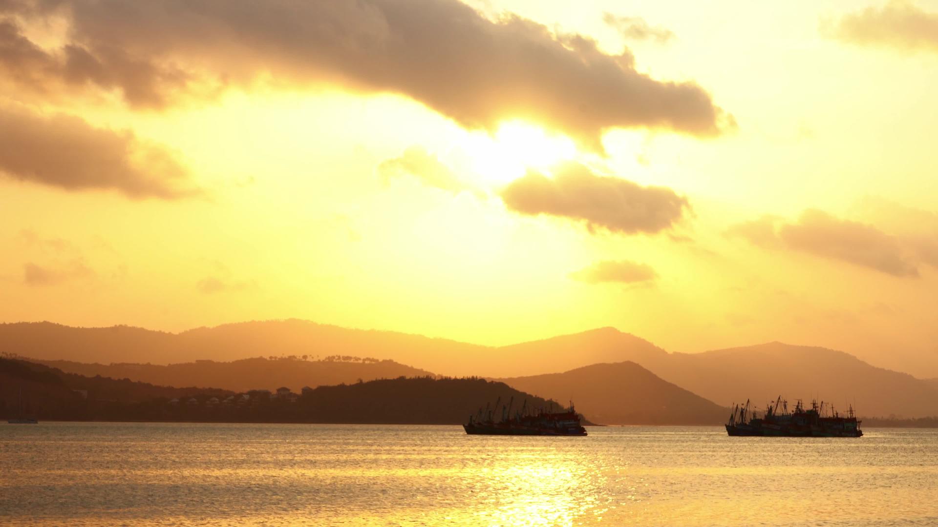 热日落渔船在热带岛屿岸边站在海湾的背景下视频的预览图