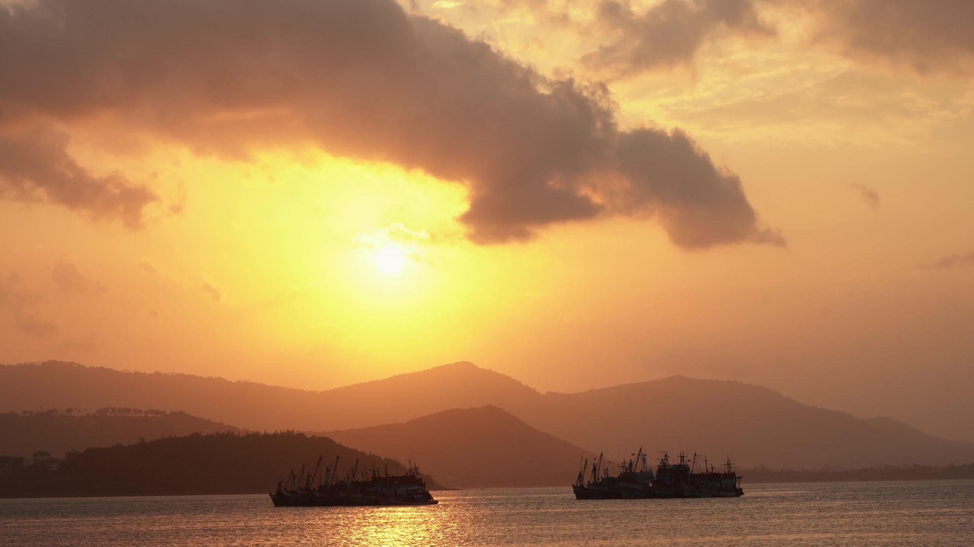 热日落渔船在热带岛屿岸边站在海湾的背景下视频的预览图