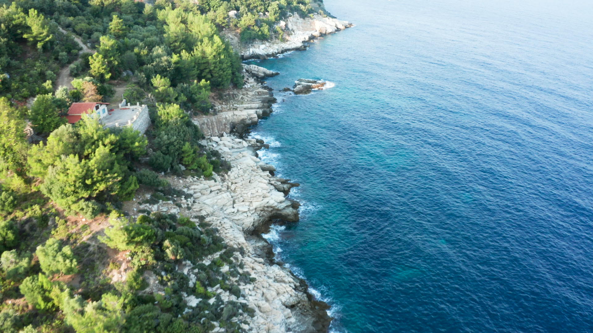 无人驾驶无人驾驶飞机飞越岩石海岸线与松绿的海水相连视频的预览图