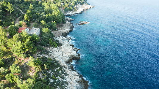 无人驾驶无人驾驶飞机飞越岩石海岸线与松绿的海水相连视频的预览图