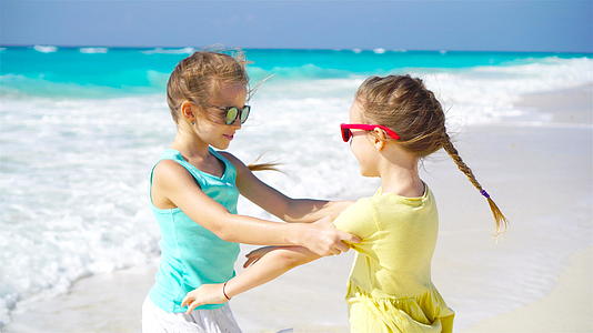 小女孩们在热带海滩玩得很开心暑假期间海滩上可爱的小女孩视频的预览图