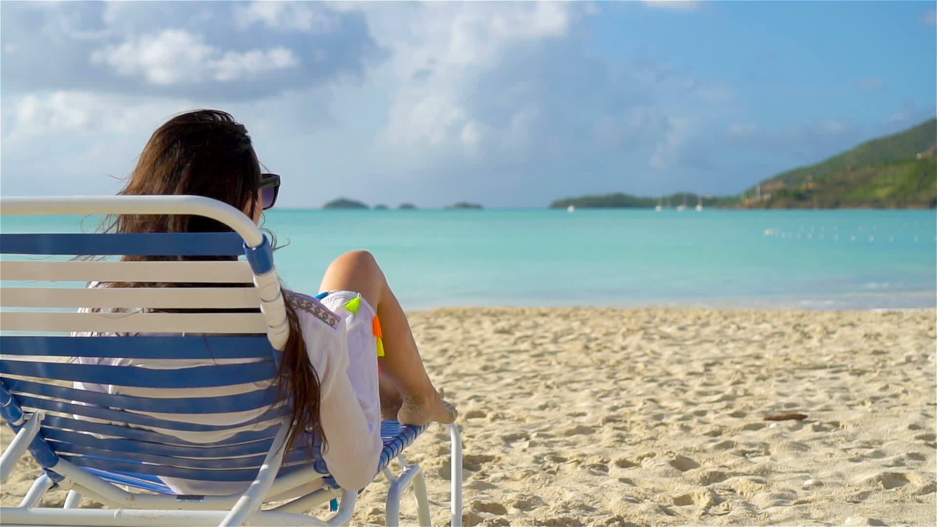 一位在热带白色沙滩上休息的妇女晒日光浴视频的预览图