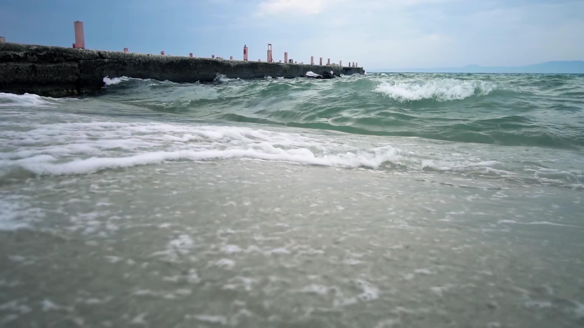 在码头附近的海滩上喷洒暴风雨视频的预览图