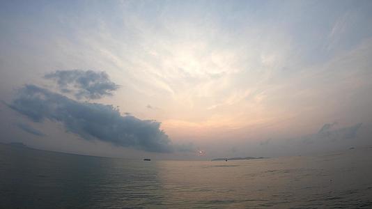 海浪和船底的云在日出的快速移动中照亮了天空中黎明的晨光视频的预览图