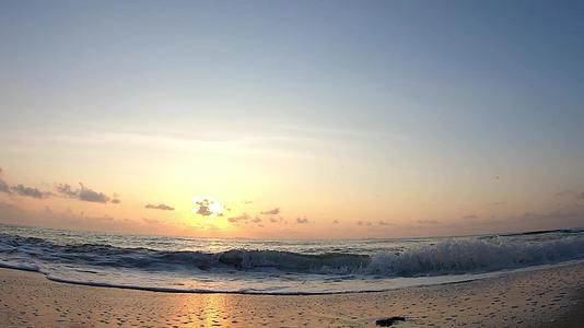 海浪击中海滩吞下飞舞的背景云和日出的金光早上在泰国视频的预览图