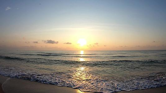 海浪击中海滩吞下飞舞的背景云和日出的金光早上在泰国视频的预览图