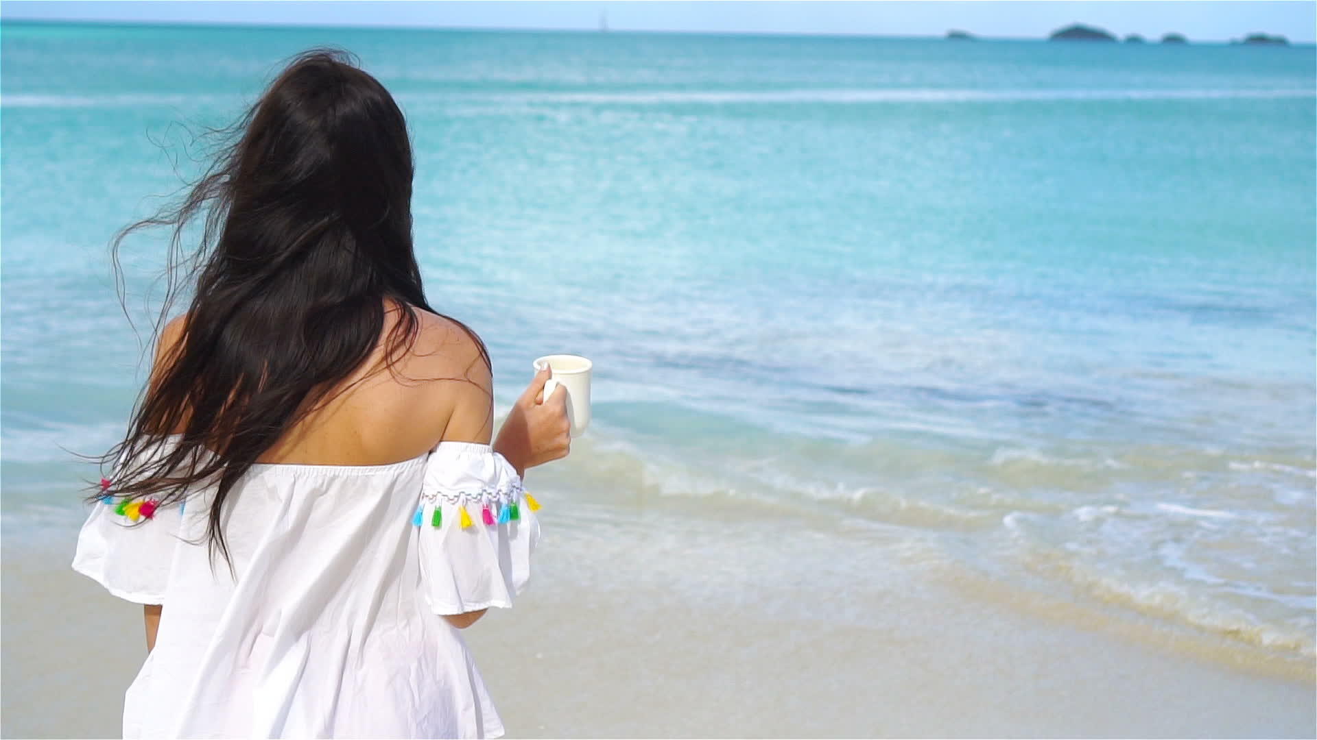 在白热带海滩上喝热咖啡的年轻女性慢动作视频的预览图