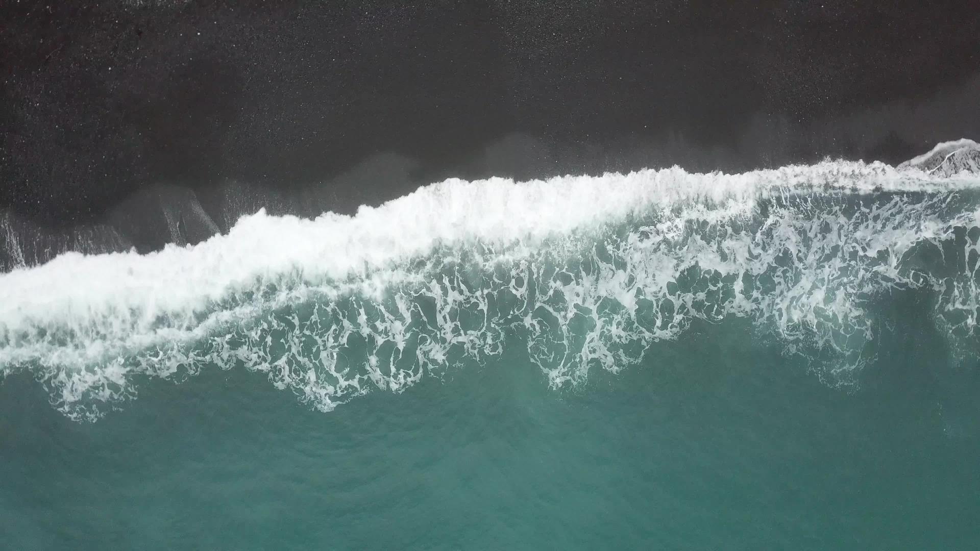 在空中观察波浪在海滩上喷洒视频的预览图