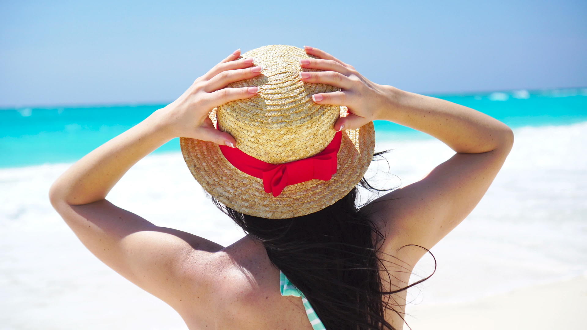 在白色的海滩上一个美丽的女人在暑假里戴着帽子视频的预览图
