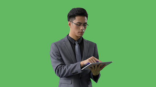 4k绿幕合成抠像穿西装戴眼镜的商务男士使用平板电脑上网视频的预览图