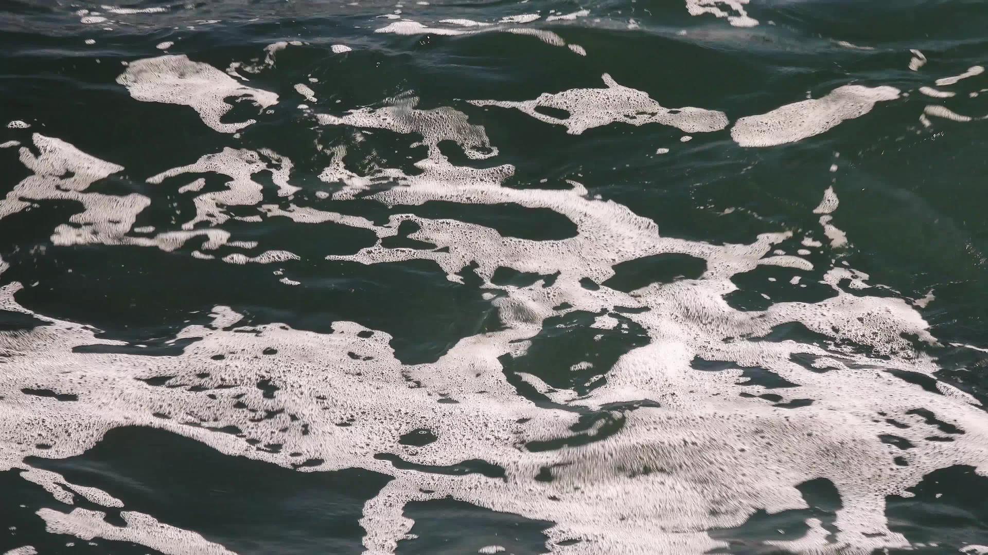 海岸附近水面上的白色泡沫太阳反射黑海视频的预览图