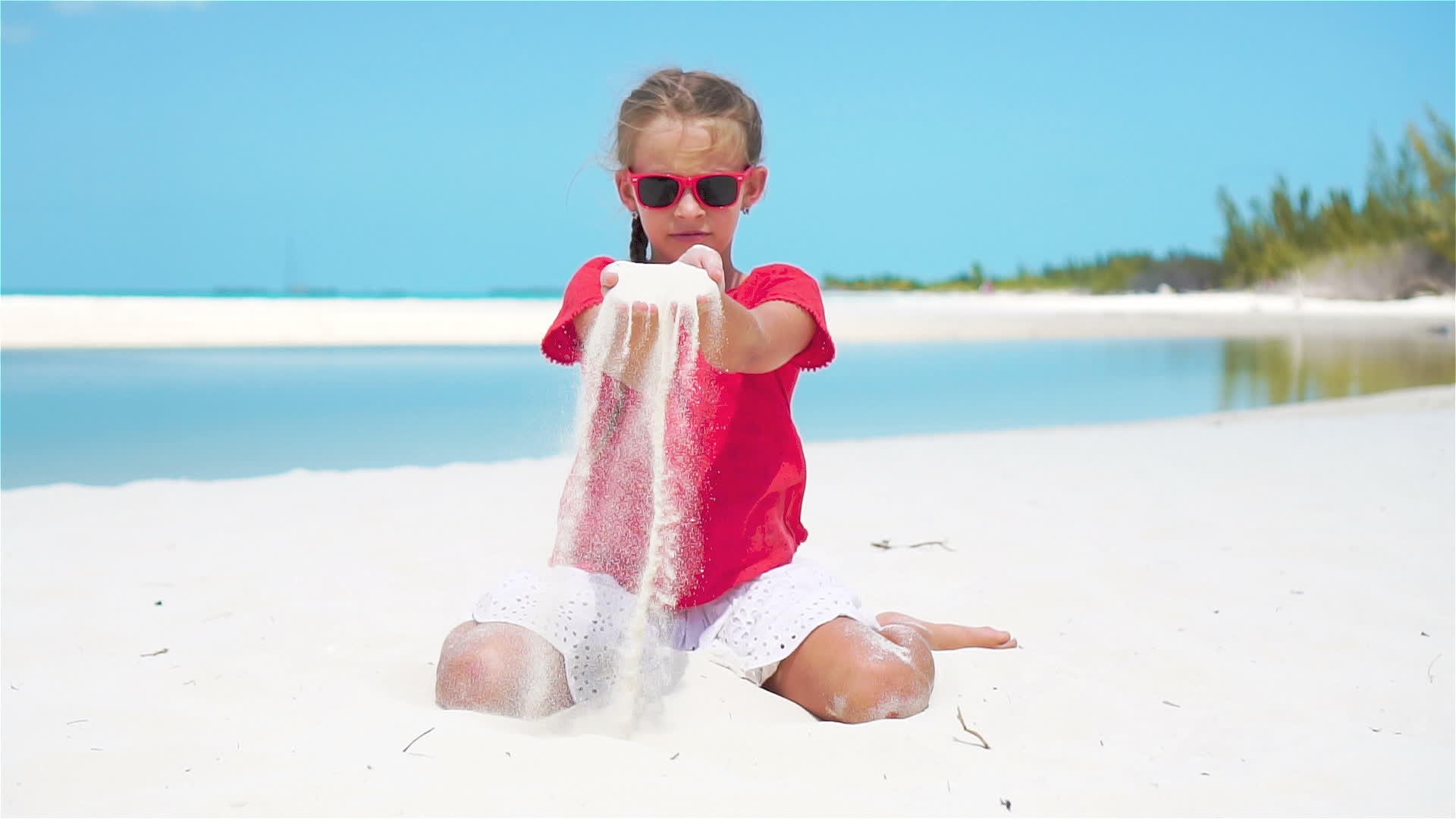 慢动作关闭女孩在热带海滩上玩美丽的白沙视频的预览图