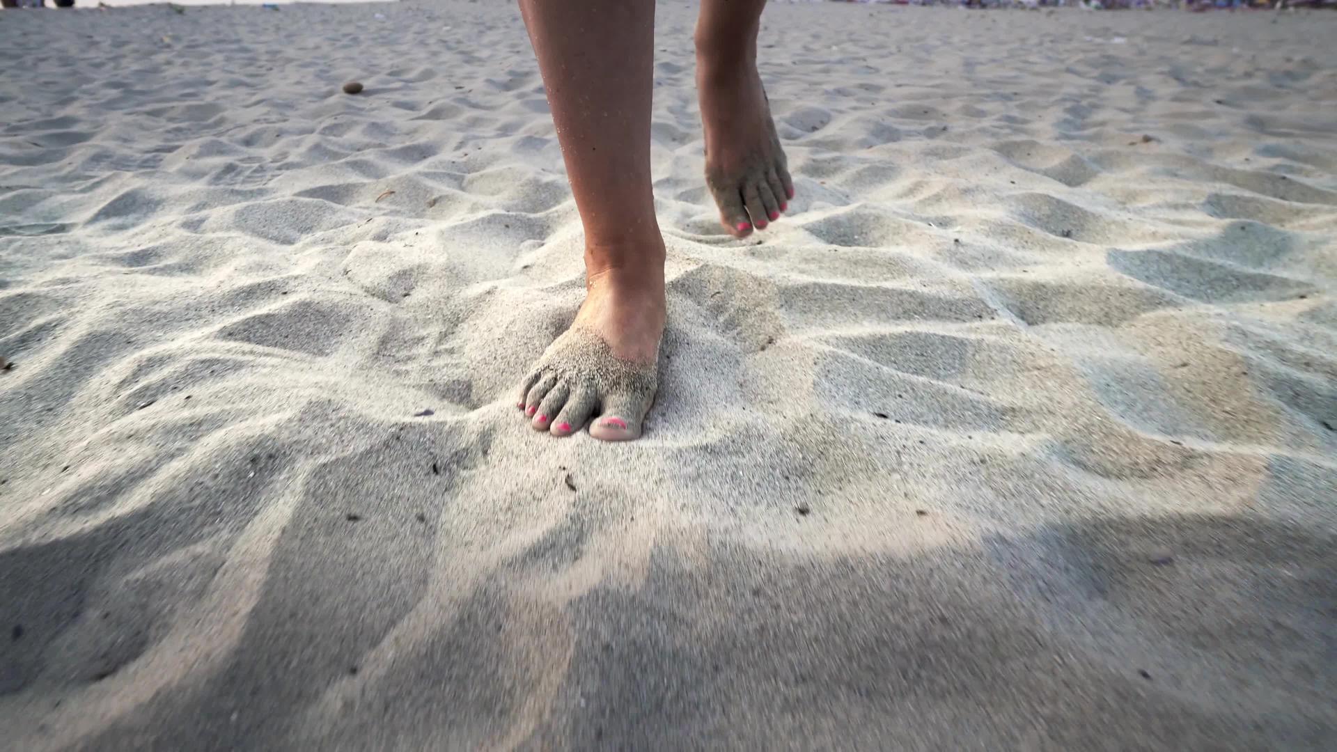 女人赤脚走在沙滩上沙子被固定的子弹击中视频的预览图