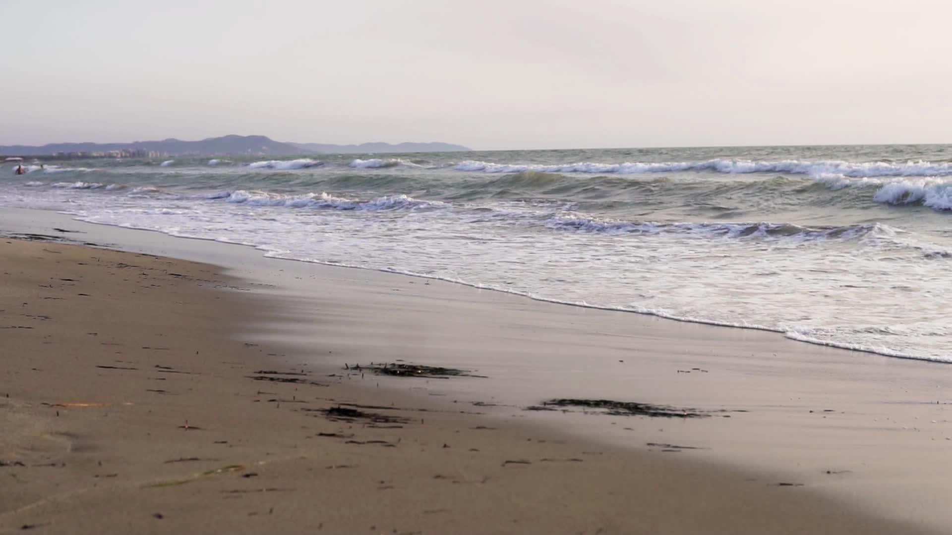 女人赤脚滩上赤脚跑步在日出电影里慢跑Dof慢动作视频的预览图