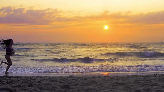 三个孩子在夏天的海滩日落时慢跑和慢跑视频的预览图