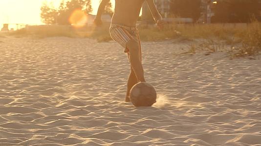 一个男孩在海滩上踢足球视频的预览图