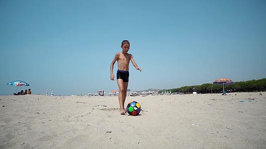 快乐的孩子们赤脚在湿沙滩上踢足球慢慢地玩运动电影视频的预览图