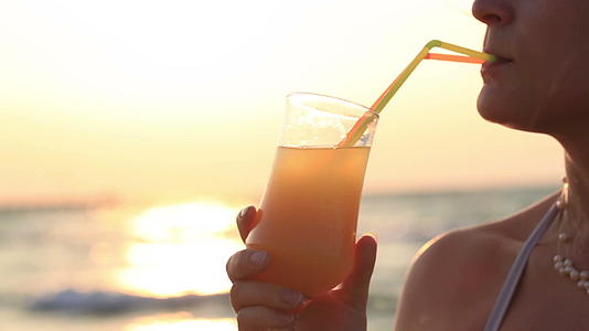 女人在日落时喝鸡尾酒视频的预览图