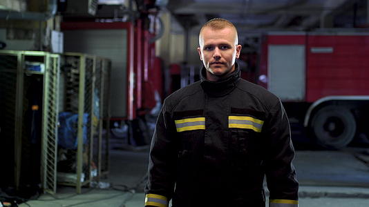 消防员穿着制服的视频肖像背景中的消防车摄像头向左移动视频的预览图