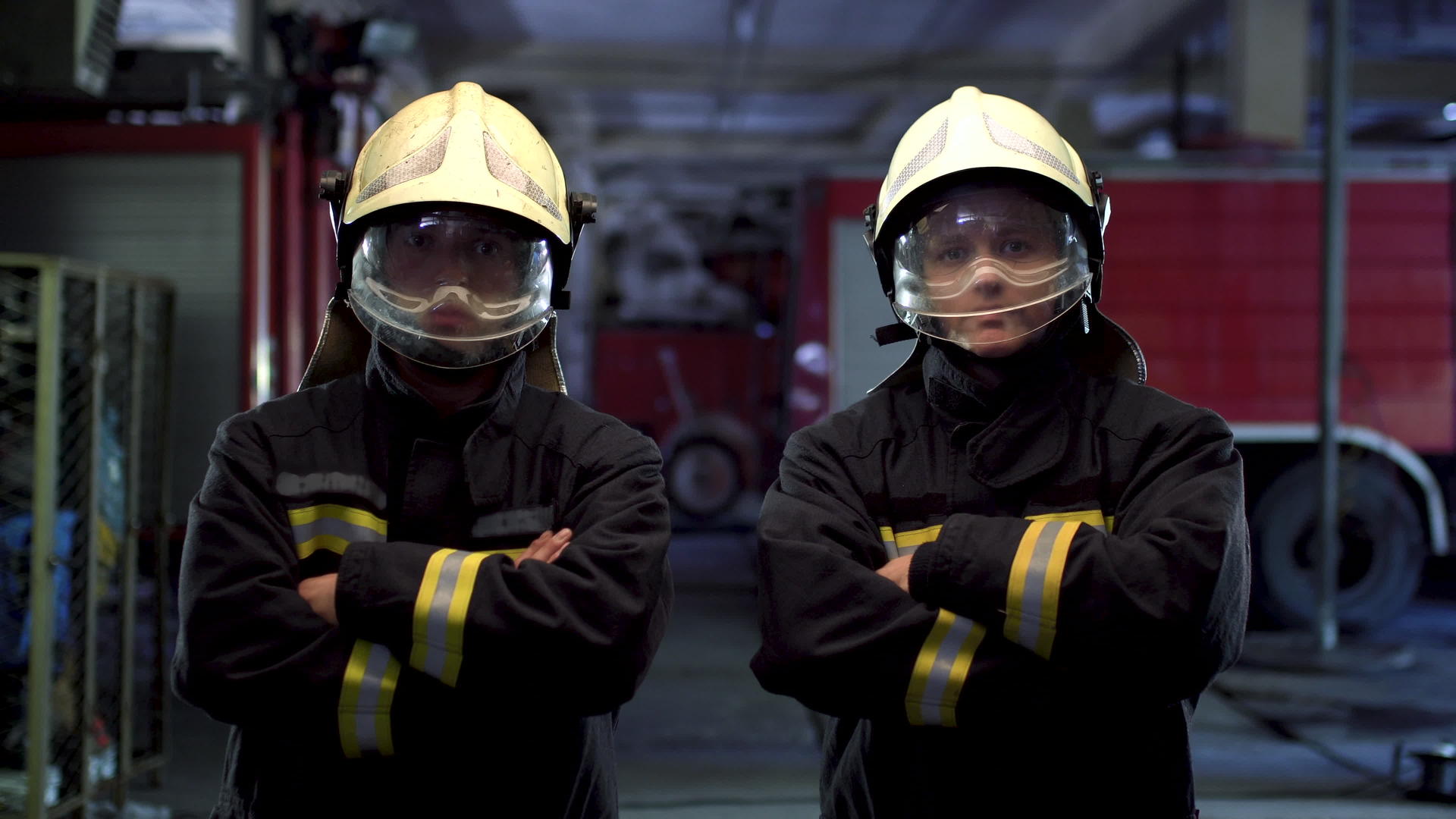 两名消防员穿着制服和防护头盔站在一起视频的预览图