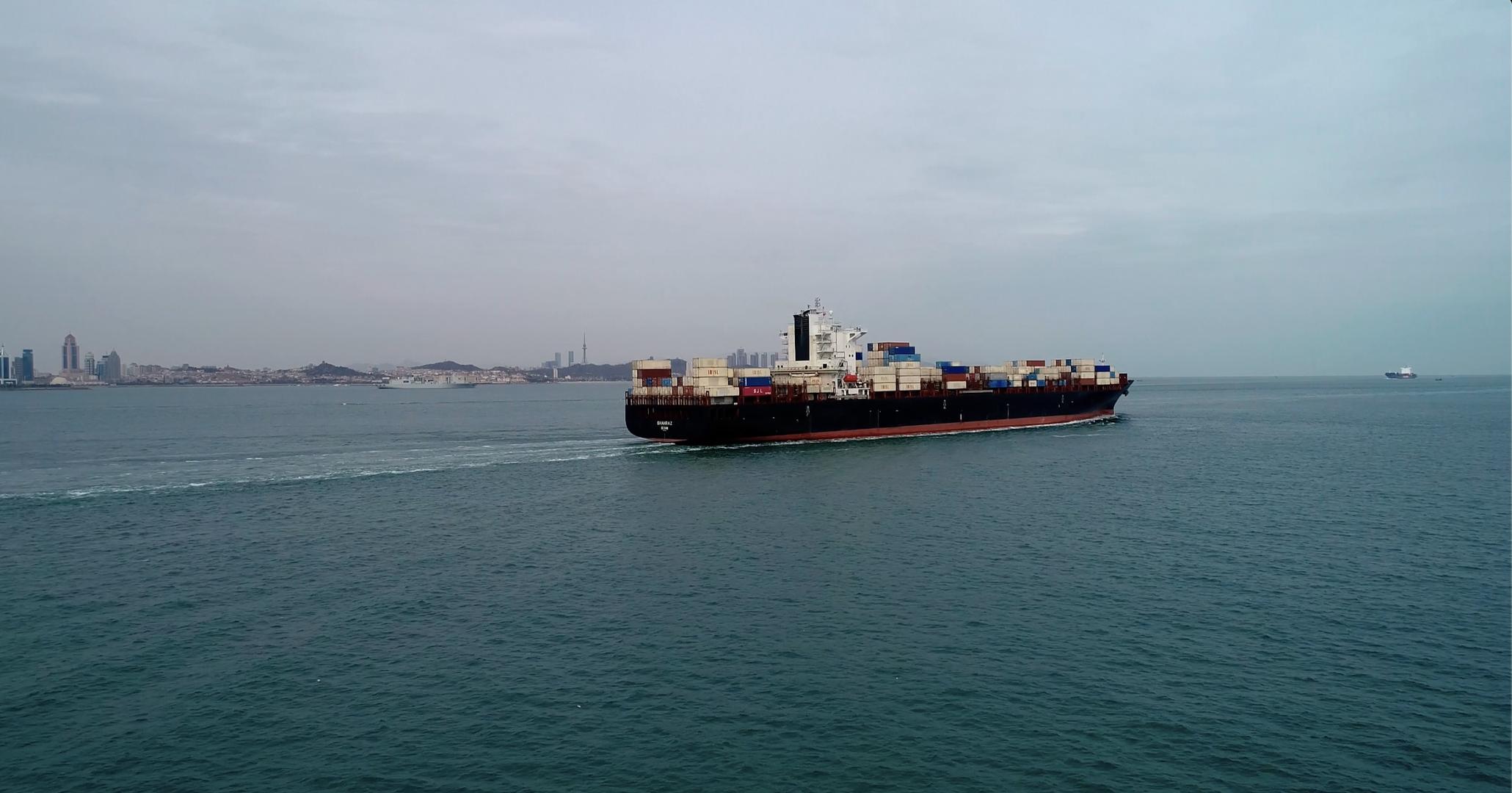 航拍行驶的远洋货轮离开港口驶向深蓝视频的预览图